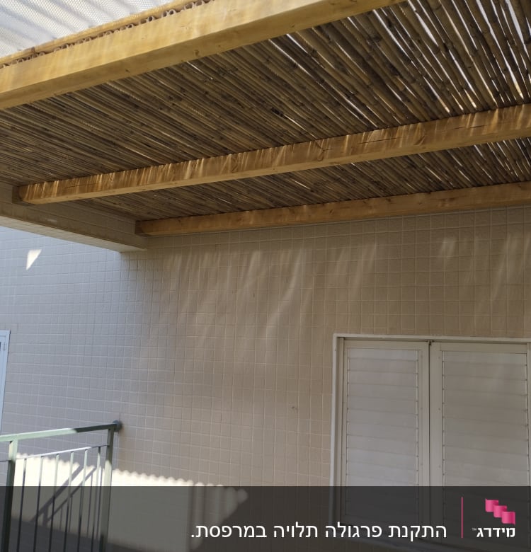 פרגולה מעץ עם קורות במרפסת